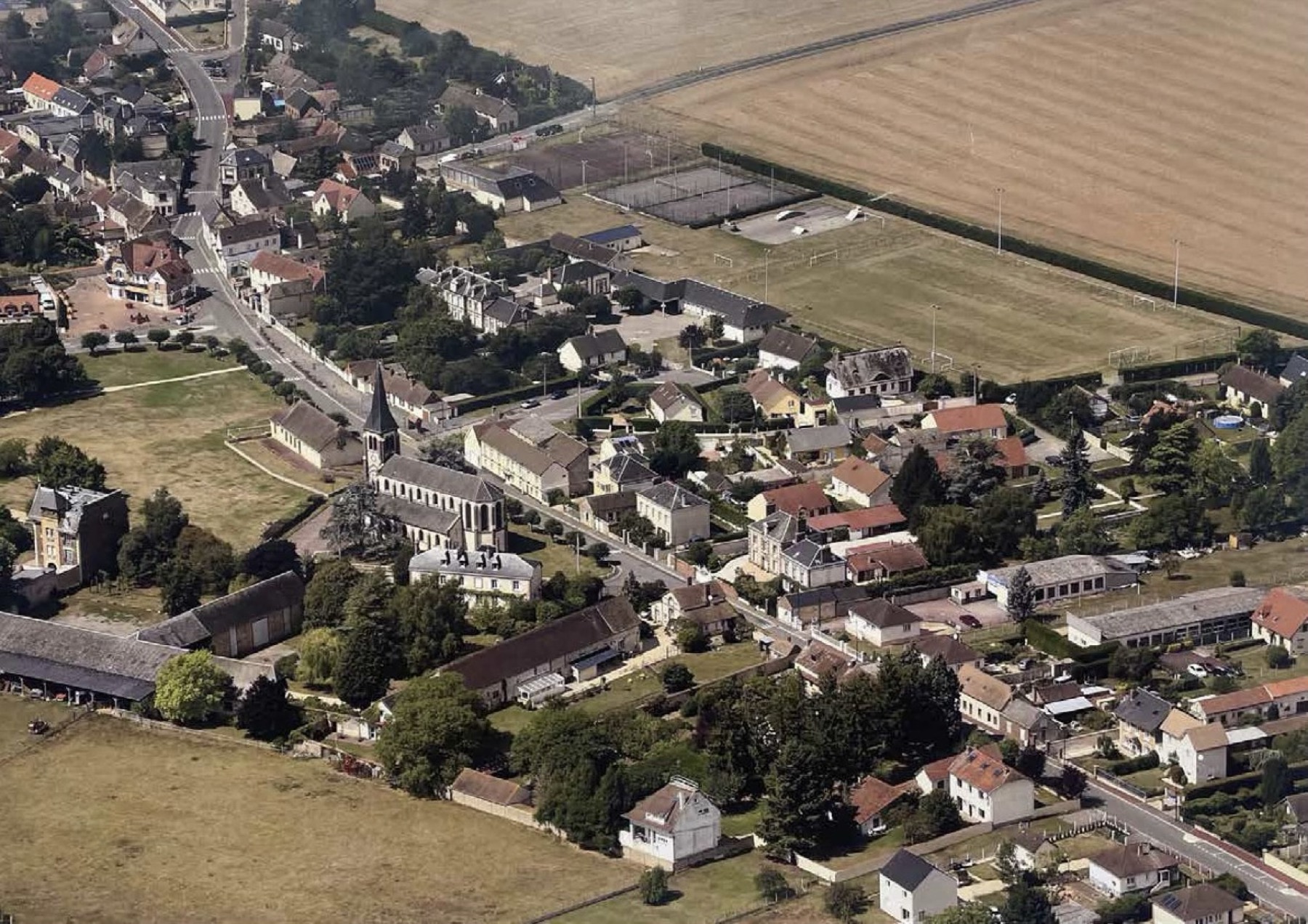 Vue aérienne de La Couture-Boussey et du domaine de La Ferme des Luthiers en bordure du bourg